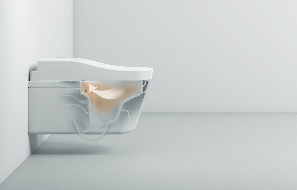 Auf dem Bild ist eine Toilette mit einem Washlet abgebildet. Sie ist in der Mitte durchsichtig gestaltet, sodass man in ihr Inneres blicken kann. Im Inneren ist eine braune Wolke abgebildet, mit einem weißen Pfeil wird verdeutlicht, dass die Luft in das Washlet gesaugt wird. 