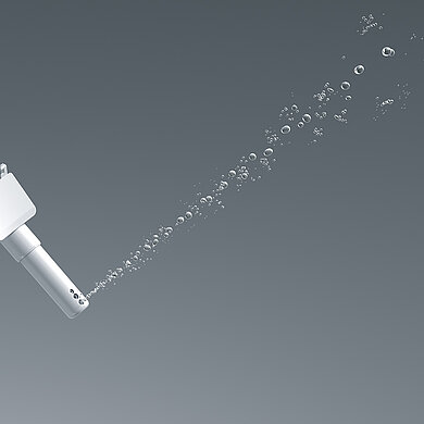 Das Bild zeigt eine Düse, aus der ein etwas weiter gefächerter Wasserstrahl kommt, der aus großen Tropfen besteht.