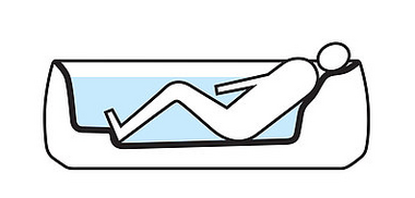 One person lies in a bath equipped with recline Comfort technology. A small elevation at the foot end of the bath serves as a footrest and prevents slipping.