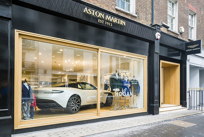 View into a shop window in which a white sports car is presented