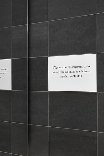 Public restroom with urinals and stalls at Louvre Museum in Paris